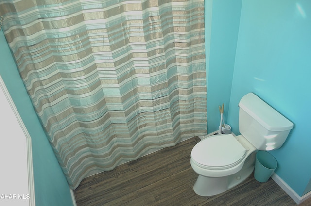 bathroom featuring hardwood / wood-style floors, toilet, and curtained shower