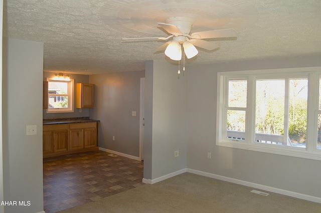 spare room featuring ceiling fan, a textured ceiling, and a wealth of natural light