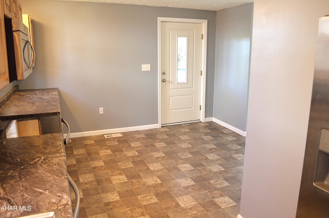 foyer entrance with a textured ceiling