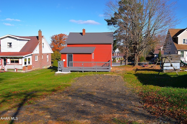 back of property with a lawn and a deck