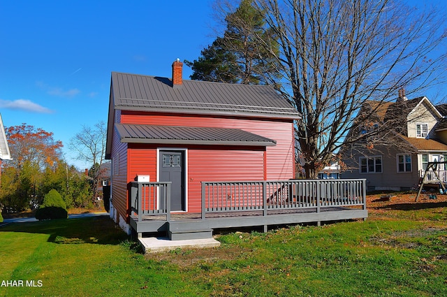 rear view of house with a yard and a deck