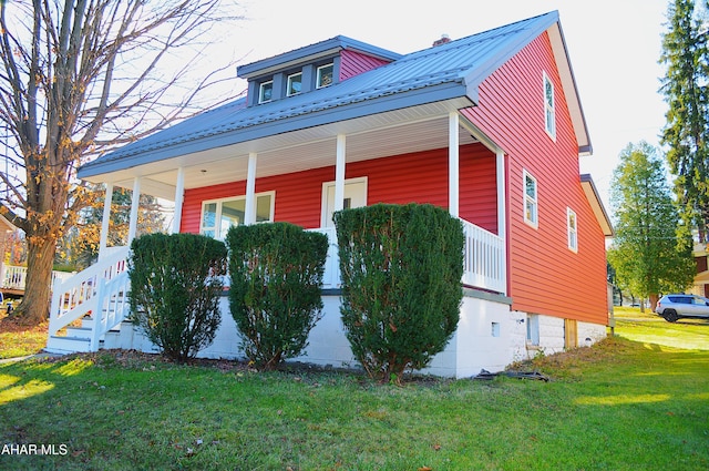 view of home's exterior with a yard and a porch