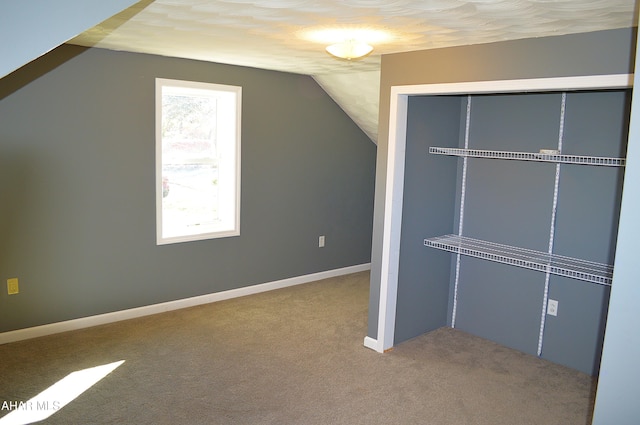 additional living space featuring carpet floors, vaulted ceiling, and a healthy amount of sunlight