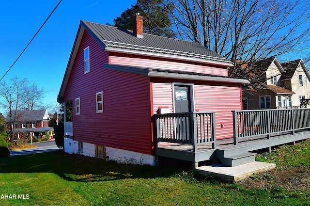 back of property with a lawn and a wooden deck