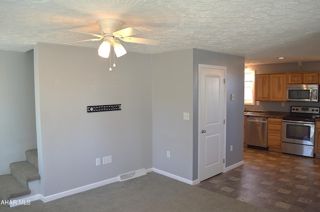 kitchen with ceiling fan, a textured ceiling, and appliances with stainless steel finishes