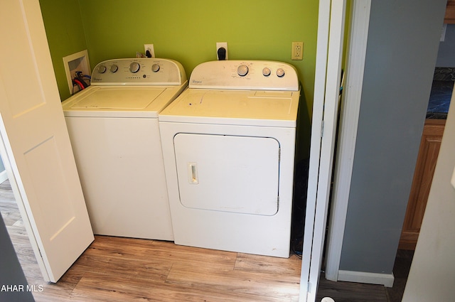 laundry room featuring washer and dryer and light hardwood / wood-style flooring