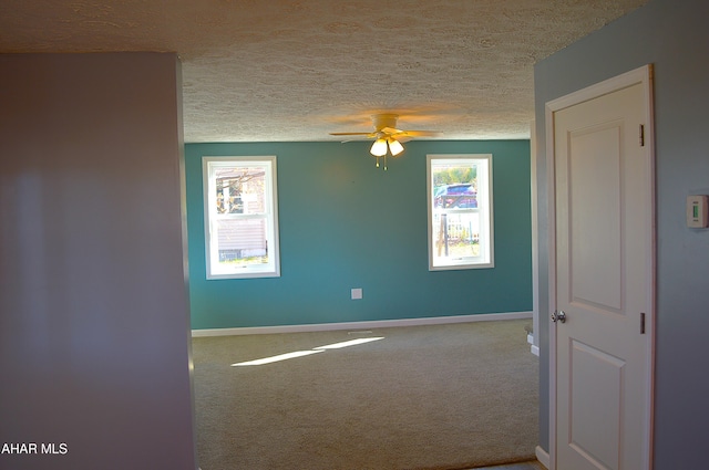 carpeted empty room featuring ceiling fan and a textured ceiling