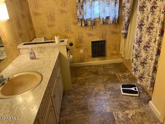 bathroom with vanity, toilet, and heating unit