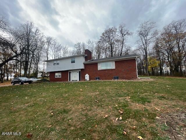 rear view of house featuring a lawn