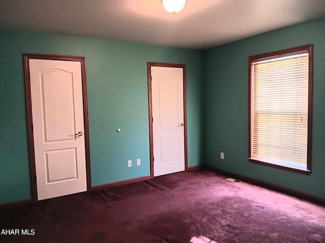 unfurnished bedroom with dark carpet