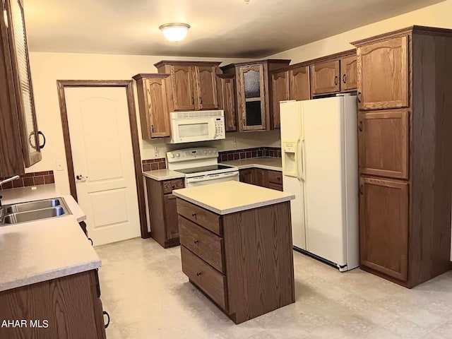 kitchen with sink, white appliances, a center island, and dark brown cabinets