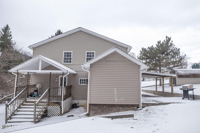 view of snow covered back of property