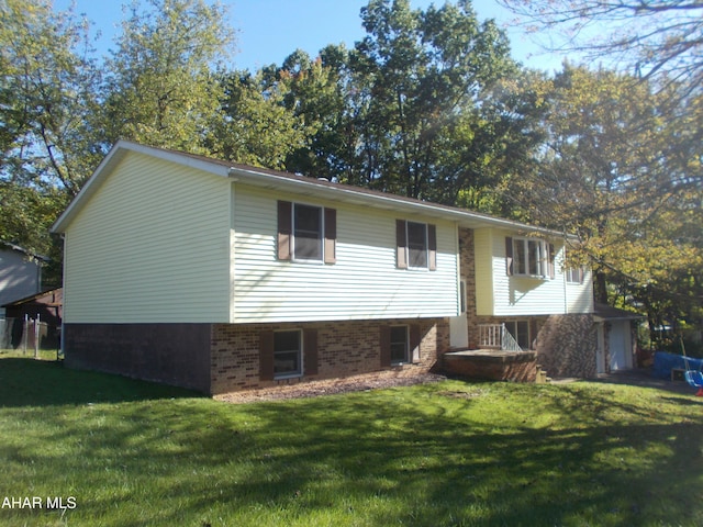 bi-level home with a front yard and brick siding