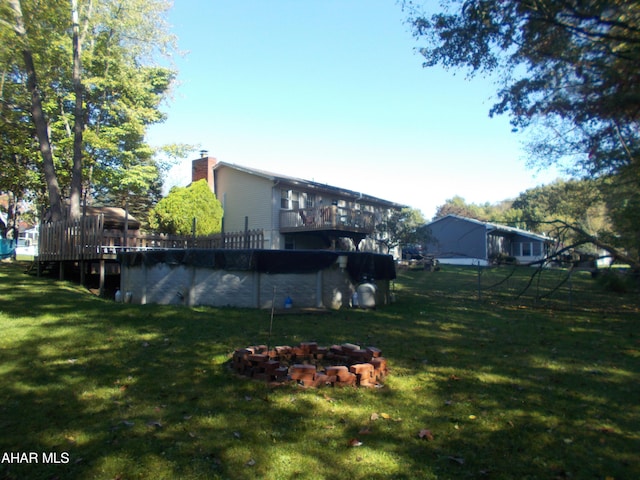 view of yard with a wooden deck and a covered pool