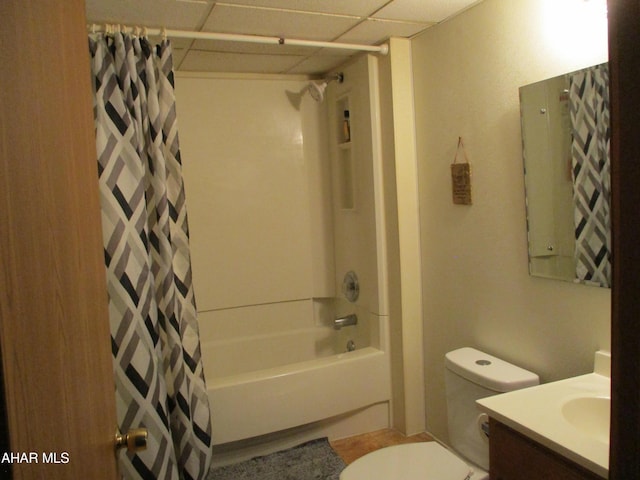 bathroom with a paneled ceiling, toilet, shower / tub combo with curtain, and vanity