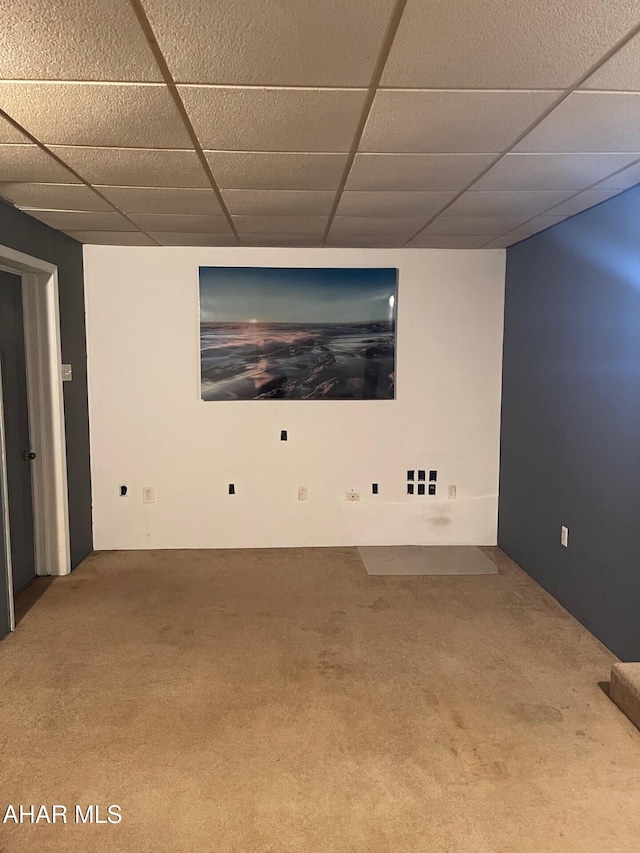 carpeted empty room featuring a drop ceiling