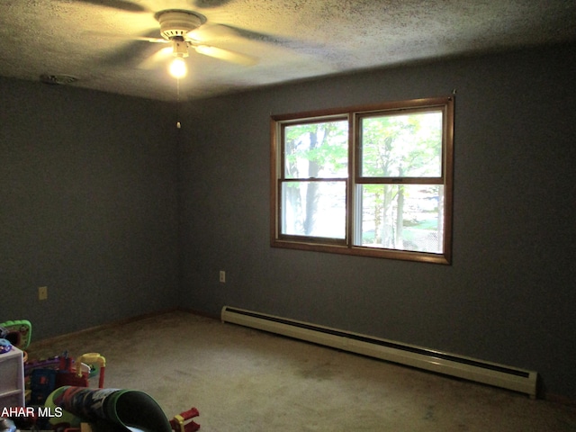 spare room featuring carpet, ceiling fan, baseboard heating, and a textured ceiling