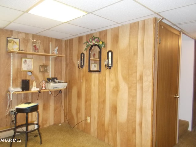 bar with wood walls, a drop ceiling, and carpet flooring