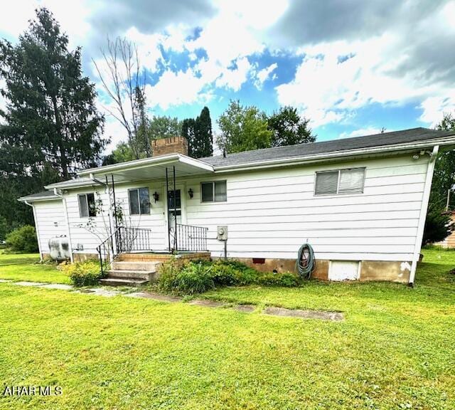 rear view of house featuring a lawn