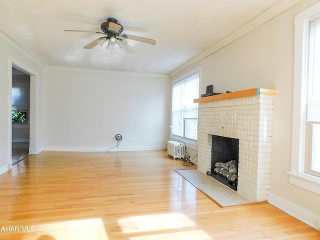 unfurnished living room featuring ornamental molding, light wood-type flooring, ceiling fan, and a fireplace