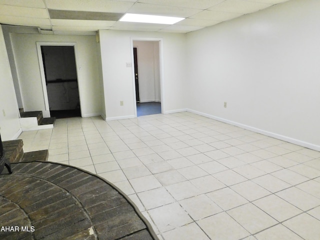 tiled empty room with a drop ceiling