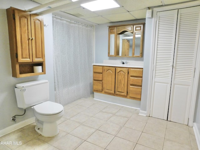 full bathroom with shower / bath combination with curtain, tile patterned flooring, vanity, toilet, and a drop ceiling