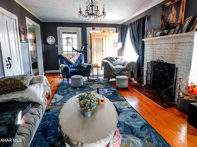 living room featuring crown molding, a chandelier, hardwood / wood-style floors, and a fireplace