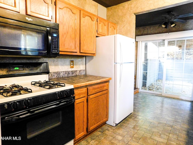 kitchen with white fridge, range with gas stovetop, and ceiling fan