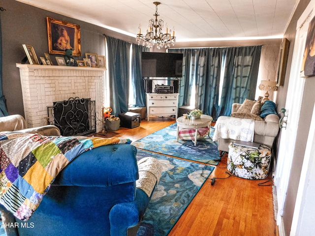 living room featuring a fireplace, a chandelier, and hardwood / wood-style floors