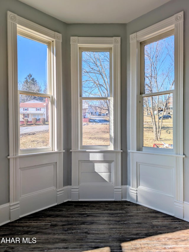 doorway to outside featuring a wealth of natural light and dark hardwood / wood-style flooring