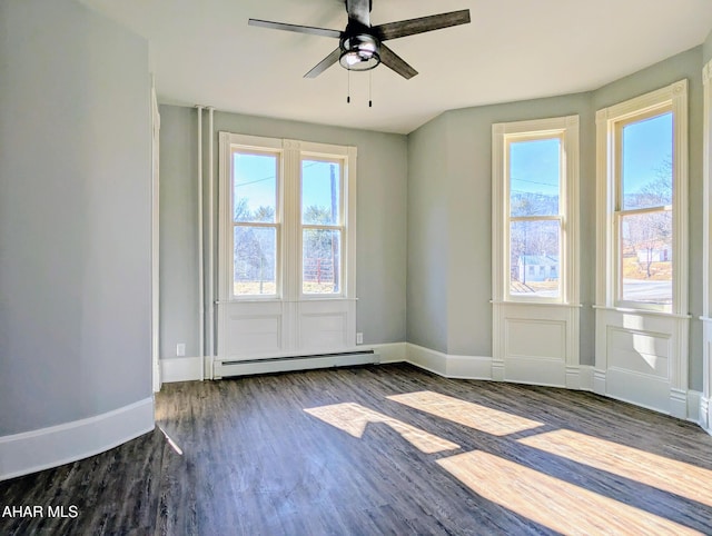 empty room with ceiling fan, dark wood-type flooring, plenty of natural light, and baseboard heating