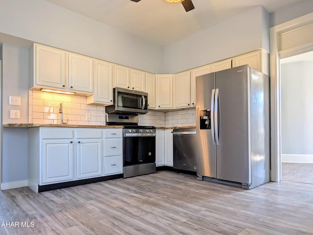 kitchen featuring stainless steel appliances, decorative backsplash, and light hardwood / wood-style flooring