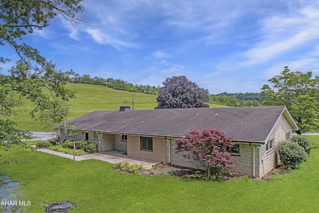 79 Mill Rd, Duncansville, PA 16635 - back of property featuring a patio area, a yard, a chimney, an attached carport, and roof with shingles