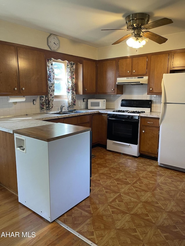 kitchen with tasteful backsplash, parquet floors, white appliances, ceiling fan, and sink