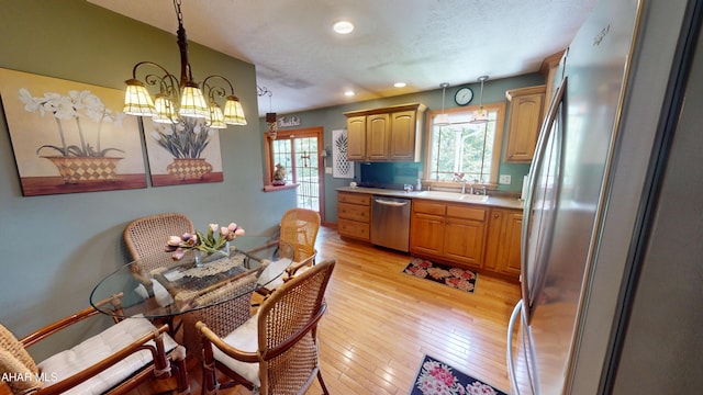 4701 Lynndale Rd, Altoona, PA 16602 - kitchen featuring stainless steel appliances, light countertops, a chandelier, light wood-style floors, and pendant lighting