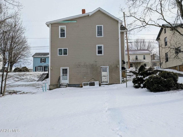 view of snow covered back of property