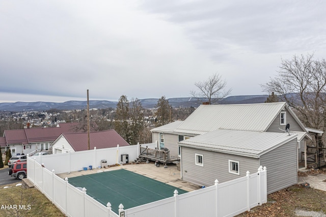 rear view of property with a swimming pool side deck with mountain view