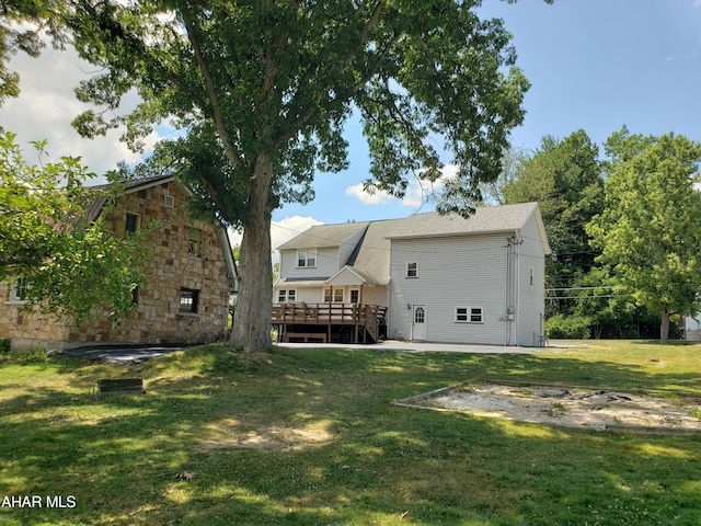 back of house featuring a yard and a deck