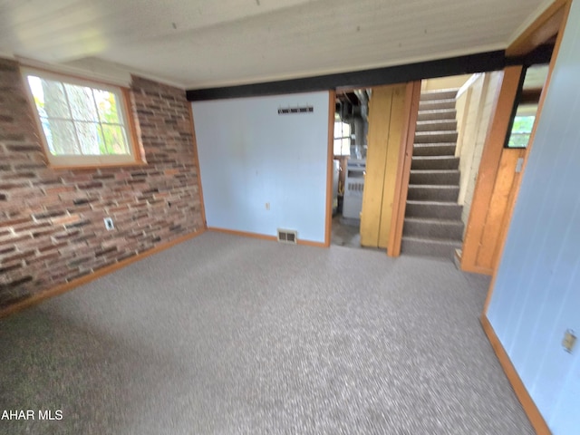 basement featuring carpet flooring and brick wall