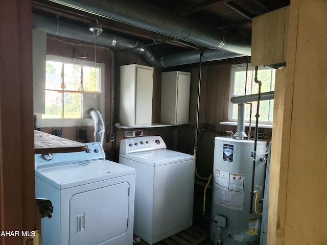 washroom featuring cabinets, independent washer and dryer, and water heater