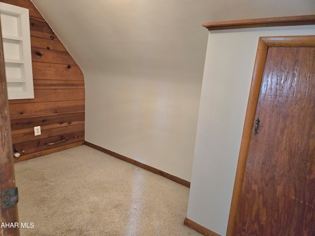 additional living space with lofted ceiling and wooden walls