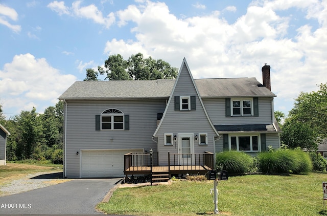 view of front of property with a front yard, a garage, and a deck