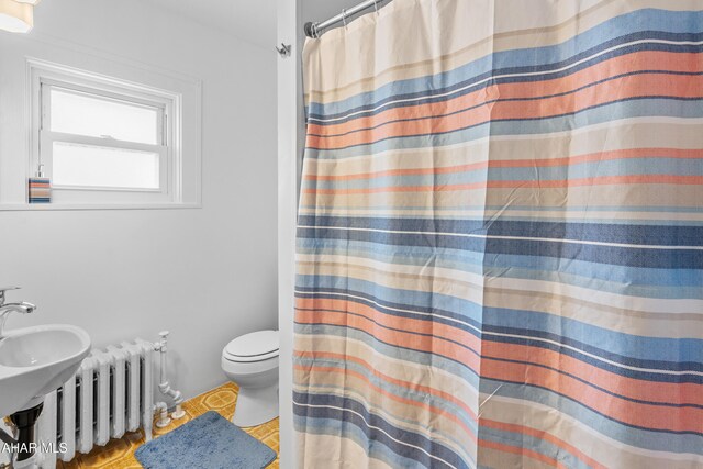 1108 22nd Ave, Altoona, PA 16601 - bathroom with radiator, toilet, and a shower with shower curtain