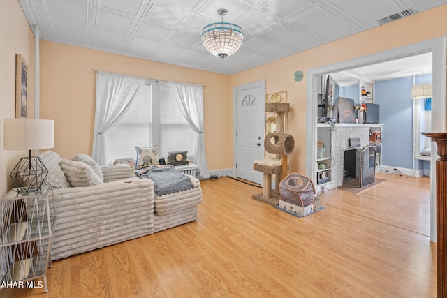 1108 22nd Ave, Altoona, PA 16601 - living room featuring wood finished floors, an ornate ceiling, a brick fireplace, and baseboards