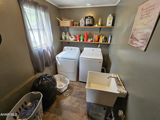 laundry room with washing machine and dryer, crown molding, and sink