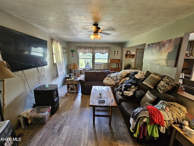 living room featuring dark hardwood / wood-style floors, ceiling fan, and a textured ceiling