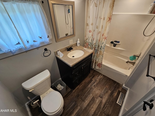 full bathroom featuring hardwood / wood-style flooring, vanity, toilet, and shower / tub combo with curtain