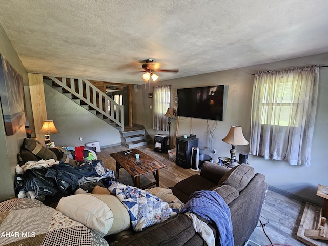 living room featuring ceiling fan, a textured ceiling, and hardwood / wood-style flooring