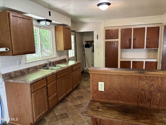179 Orchard Way, Bedford, PA 15522 - kitchen featuring dark countertops, dark tile patterned floors, tasteful backsplash, and brown cabinets