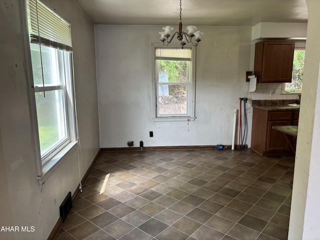 179 Orchard Way, Bedford, PA 15522 - unfurnished dining area featuring plenty of natural light, a chandelier, and dark tile patterned floors